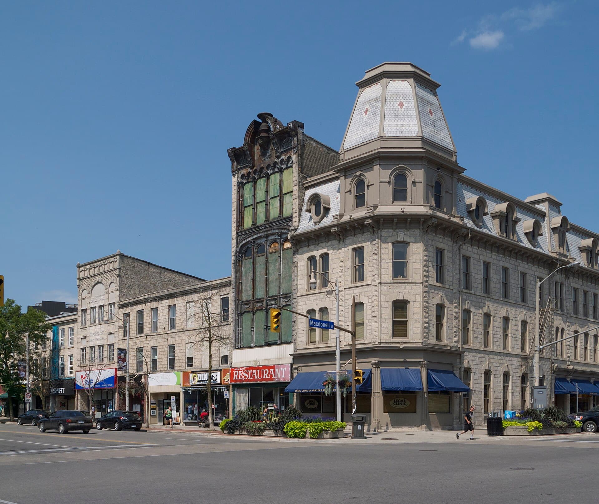 The limestone Victorian corner block at Wyndham and Macdonell Streets in downtown Guelph under a blue sky